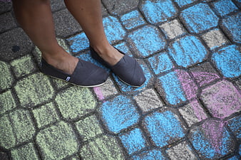 Gray slip-on shoes on colorful painted pavement