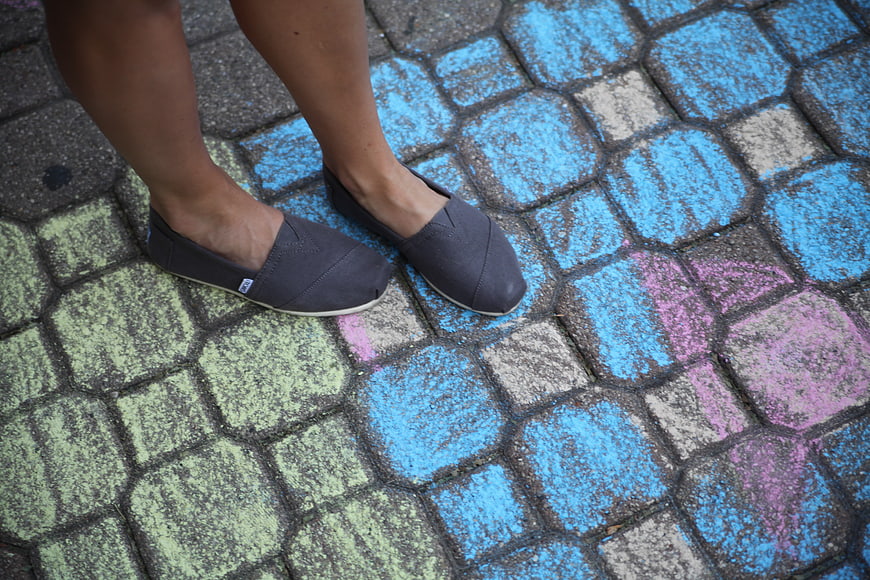 Gray slip-on shoes on colorful painted pavement