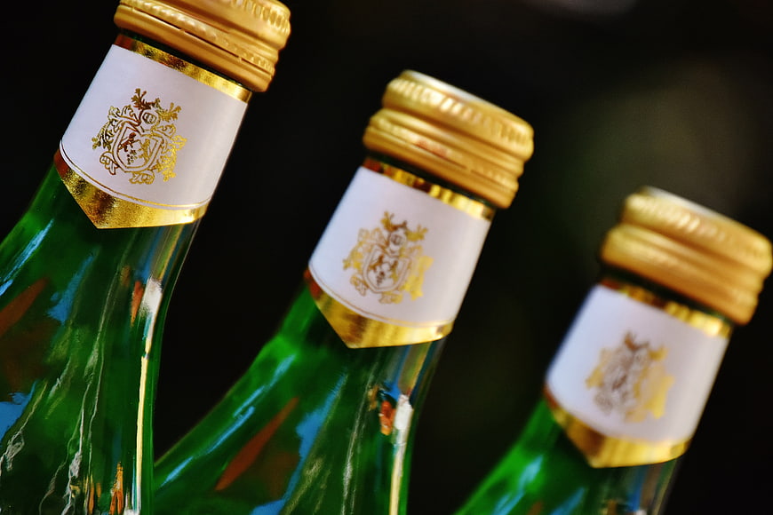 Close-up of green wine bottles with gold foil caps