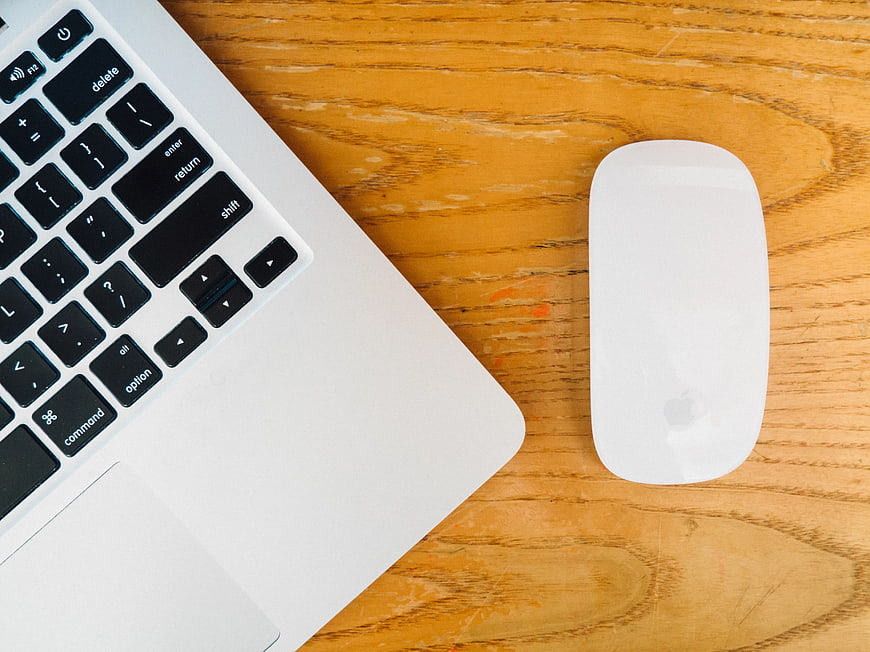Top View of Laptop and Mouse on Wooden Desk