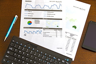 Printed Google Analytics Dashboard Report On Desk With Keyboard And Smartphone