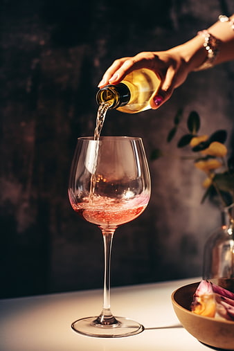 Hand Pouring Rosé Wine into a Glass