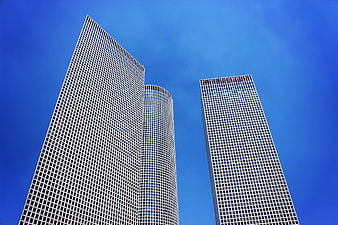 Low angle view of modern skyscrapers against blue sky