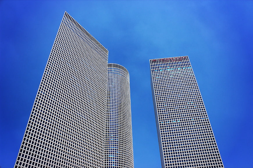 Low angle view of modern skyscrapers against blue sky