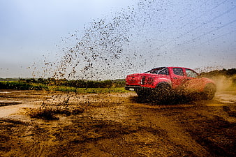 Red Pickup Truck Splashing Through Mud