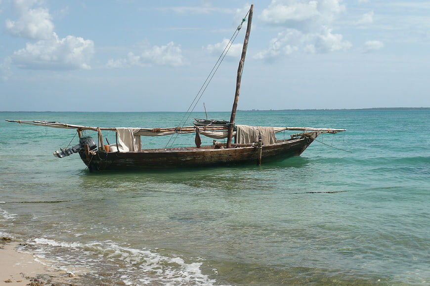 Traditional wooden dhow boat anchored in turquoise Zanzibar waters