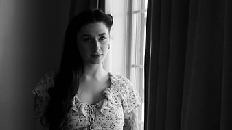 Black and white portrait of woman by window