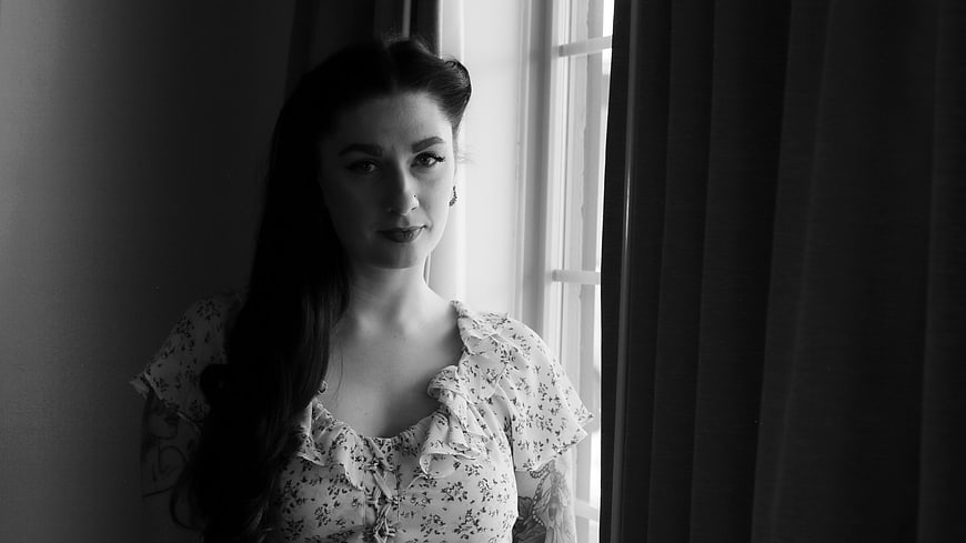 Black and white portrait of woman by window