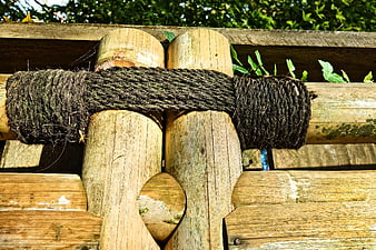 Close-up of weathered bamboo fence with thick rope tie