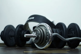 Close-up of gym dumbbells and weightlifting belt on floor