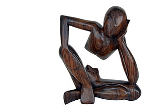 Abstract wooden sculpture of a thinking figure on white background