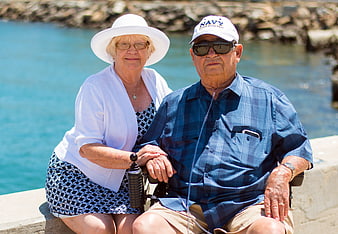 Senior couple sitting together outdoors by the water