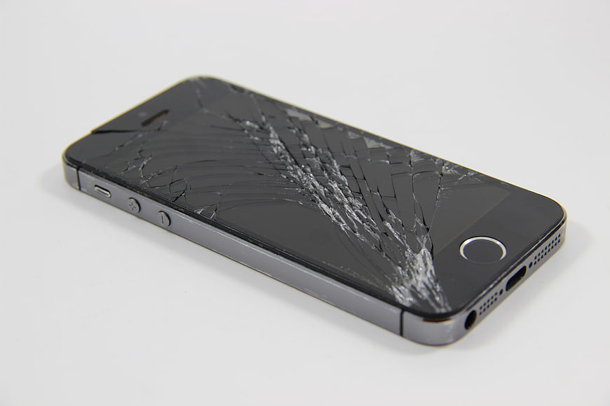 Broken Smartphone with Shattered Screen on White Background