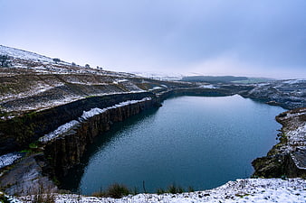 Snowy Winter Landscape with Deep Blue Quarry Lake
