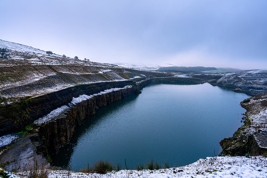 Snowy Winter Landscape with Deep Blue Quarry Lake
