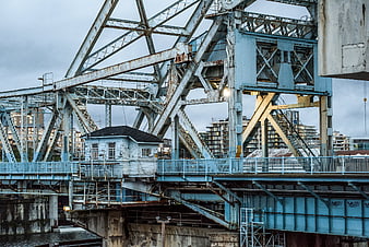 Blue steel truss bridge with industrial control house