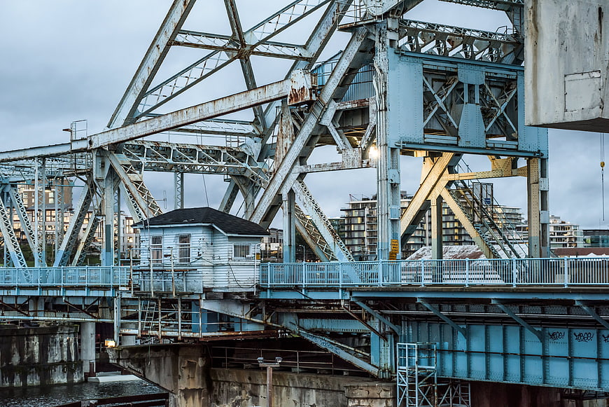Blue steel truss bridge with industrial control house