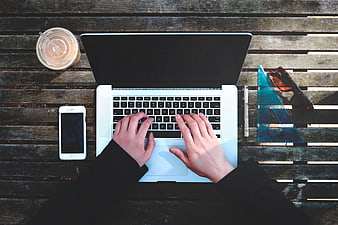 Top View of Hands Typing on Laptop at Wooden Table