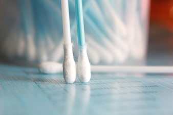 Cotton Swabs Standing On Blue Wooden Surface