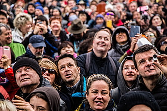 Diverse crowd of people looking up with curiosity and excitement