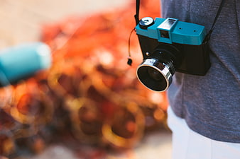 Vintage Blue Camera Hanging on Shoulder with Autumn Background