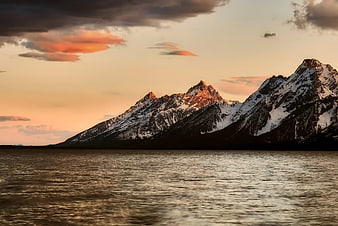 Snowy Mountain Peaks at Sunset Over Calm Lake