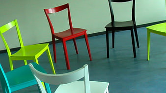 Colorful chairs arranged in a circle on blue floor