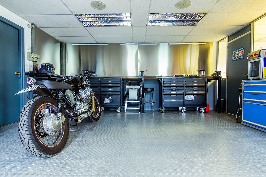 Custom motorcycle parked in a clean, organized mechanic workshop