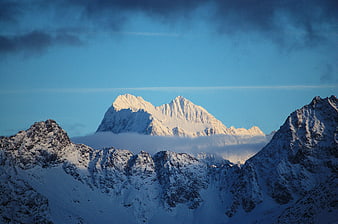 Snowy Mountain Peaks at Sunrise with Blue Sky
