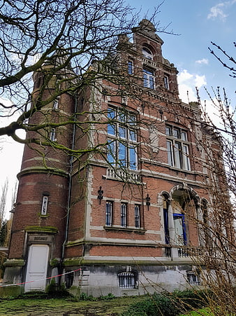 Historic Red Brick Mansion with Ornate Architecture and Bare Trees