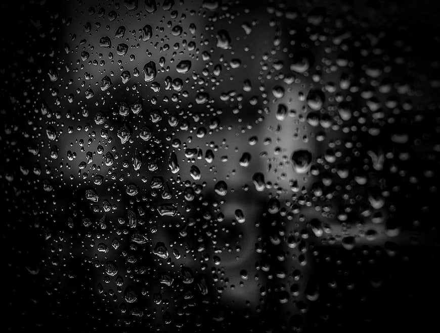 Black and white raindrops on glass window texture