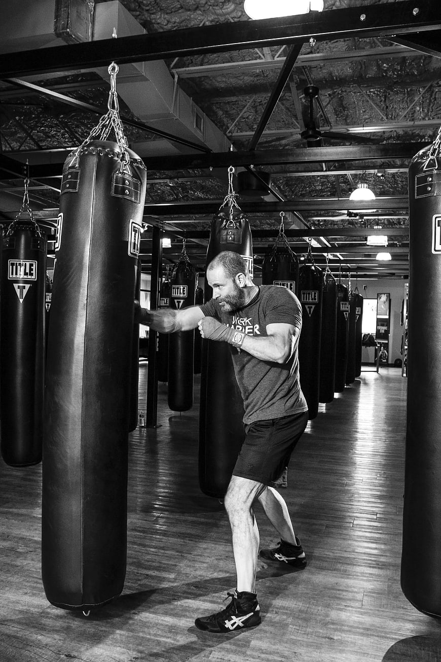 Man Punching Heavy Bag in Boxing Gym