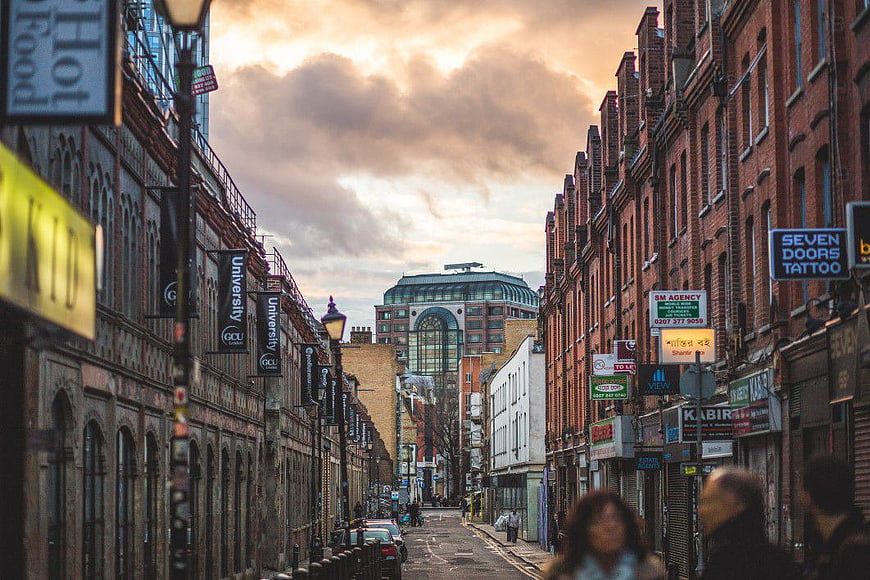Busy London Street Scene with Brick Buildings and Cloudy Sky