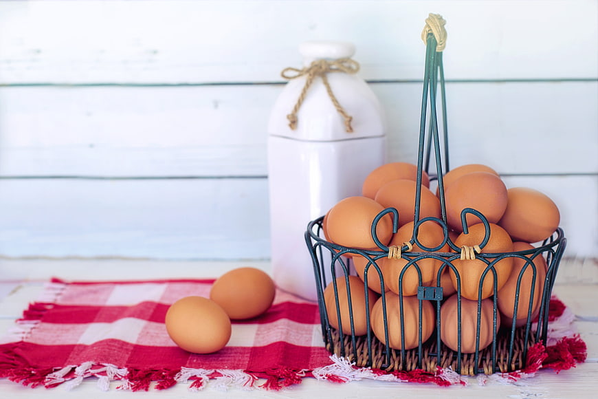Fresh Brown Eggs in Wire Basket on Red Checkered Cloth