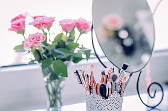 Pink Roses and Makeup Brushes on Vanity Table