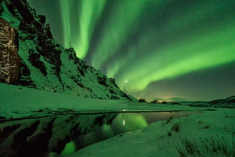 Vibrant Green Aurora Borealis Over Snowy Mountain River