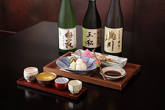 Traditional Japanese Sake Bottles and Appetizers on Wooden Tray