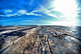 Low Angle View of Weathered Wooden Boardwalk Leading to Ocean