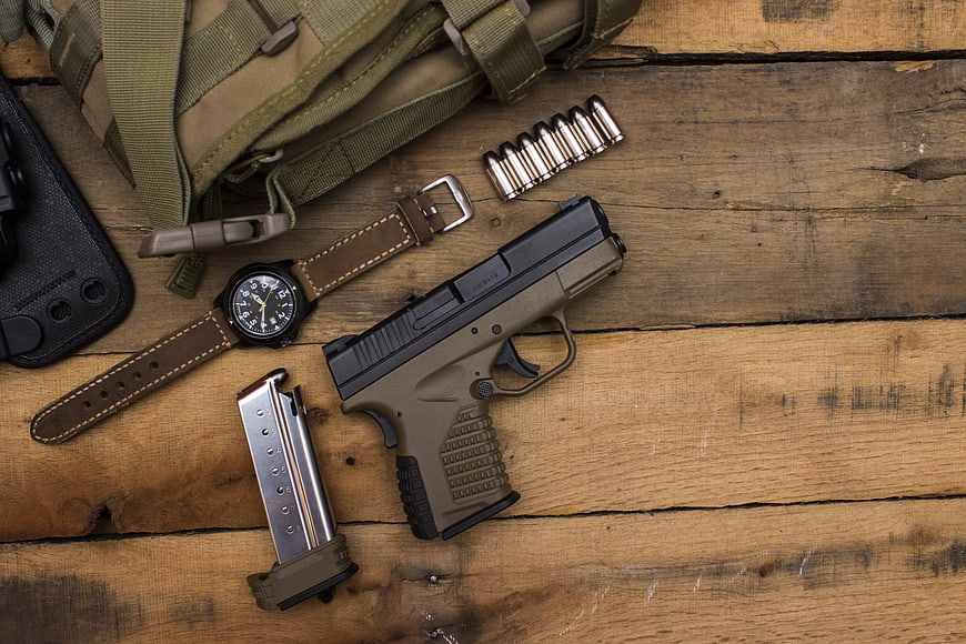 Tactical Pistol, Magazine, and Watch Arranged on Rustic Wooden Table