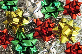 Colorful metallic Christmas gift bows on silver tinsel background