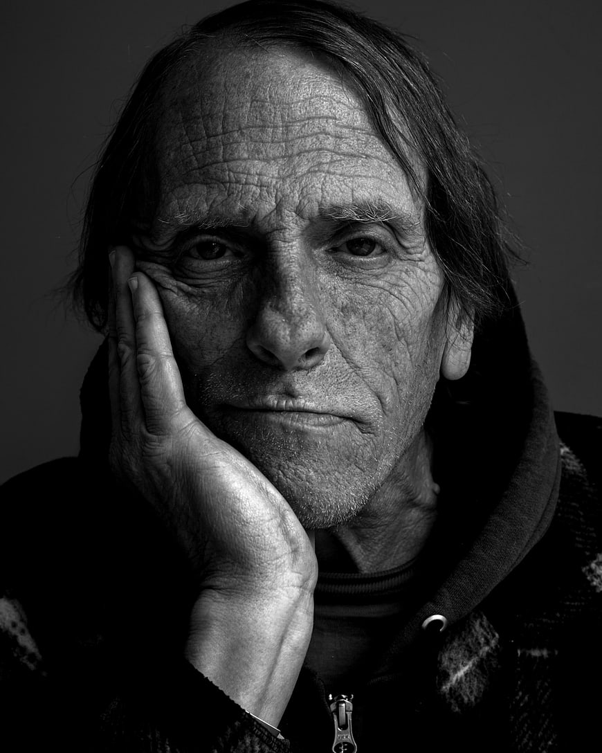 Black and white portrait of elderly man with hand on face