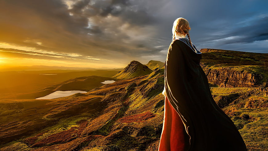 Woman in Medieval Cloak Overlooking Scottish Highlands at Sunset