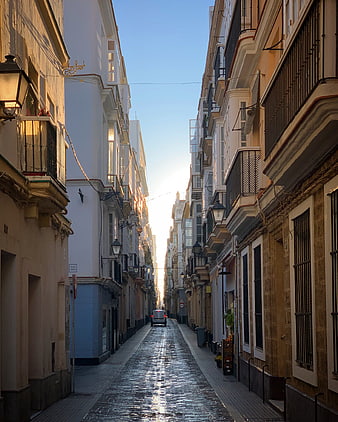 Narrow European Street with Sunlight and Cobblestones