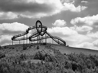 Black and white spiral staircase on a hill with clouds