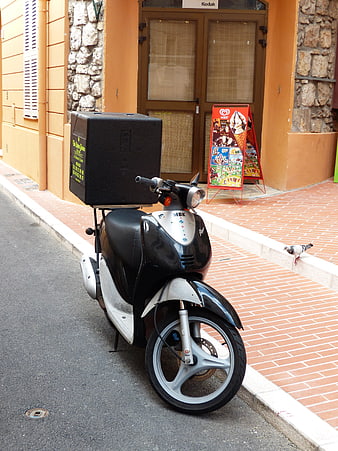 Black MBK Scooter With Pizza Delivery Box Parked On Street
