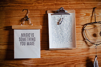 Inspirational quotes on clipboard and paper hanging on wooden wall