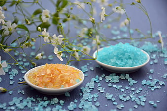 Bath salts and baby's breath flowers on blue background