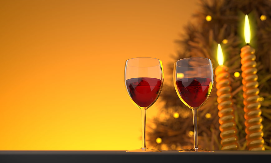 Two glasses of red wine with candles and Christmas tree background