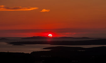 Vibrant red sunset over coastal islands and ocean