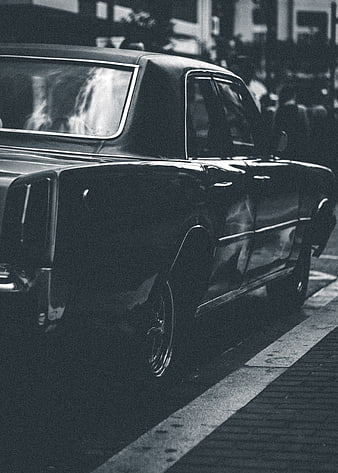 Vintage black car parked on city street at night